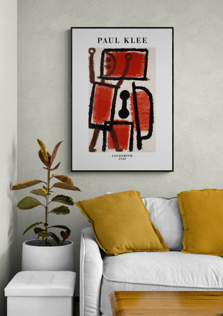 Framed print of Paul Klee's "Locksmith 1940" with geometric abstract figure, displayed above a modern sofa.