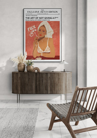 Framed "Not Giving a Fuck Artsy Edition" poster displayed above a wooden console in a modern living room.