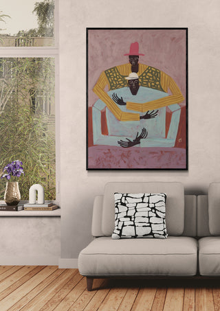 The Hug by Studio IMO artwork displayed above a beige sofa in a cozy, modern living room.