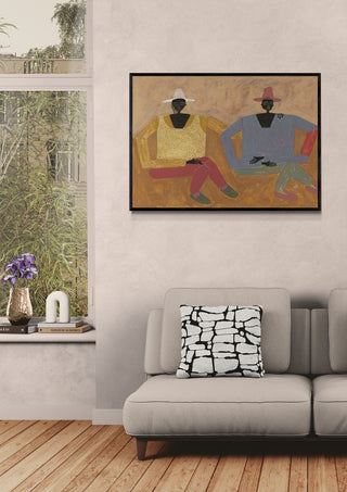 Framed abstract artwork above a modern beige sofa in a stylish living room with large window and wooden floor.