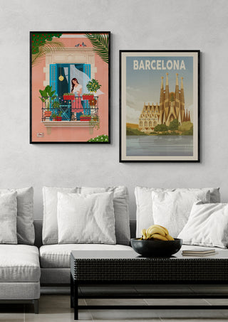 Two framed posters above a sofa, featuring Barcelona art by Petra Holikova and Sagrada Familia illustration.